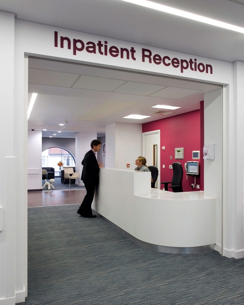 Person talking to receptionist at inpatient reception inside Montefiore hospital