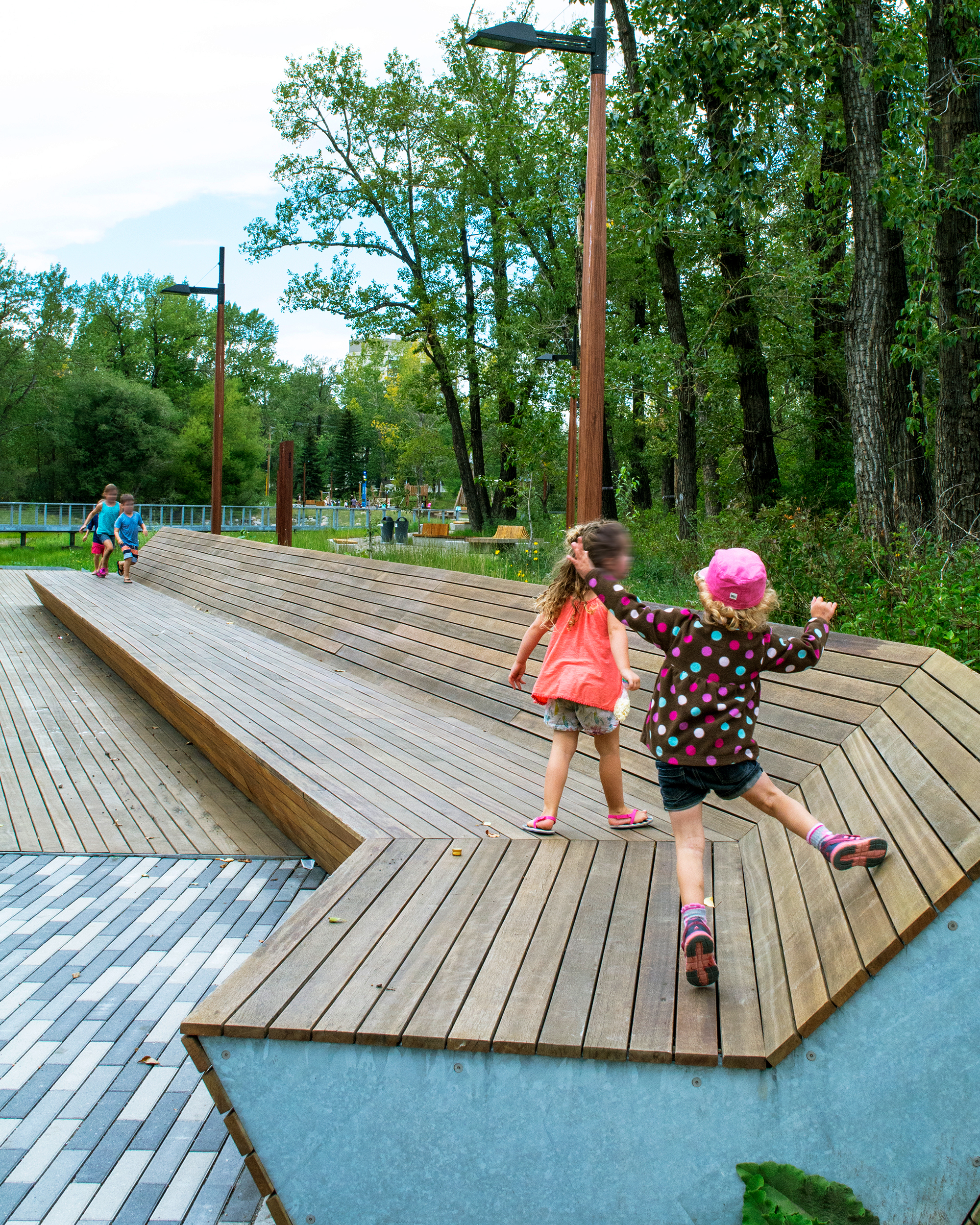 Two children standing on long wooden bench