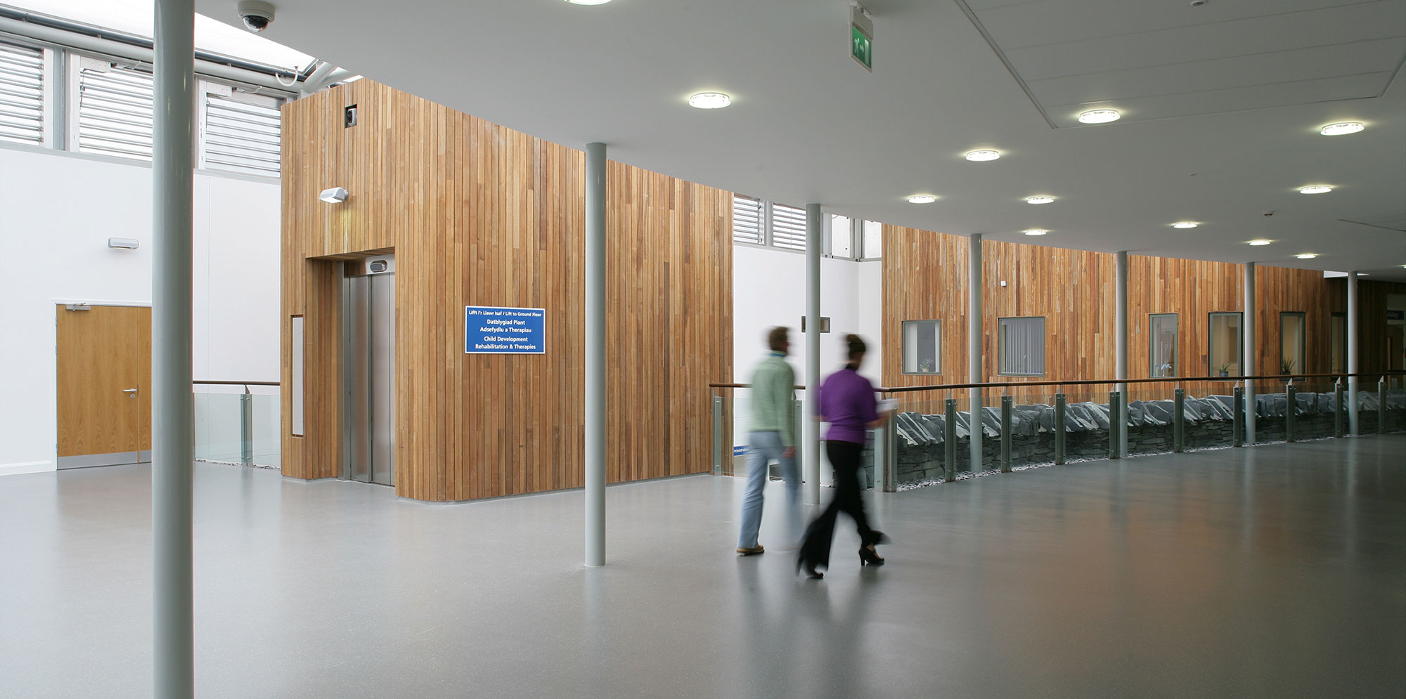 Two people walking down hallway inside Ysbyty Alltwen Hospital