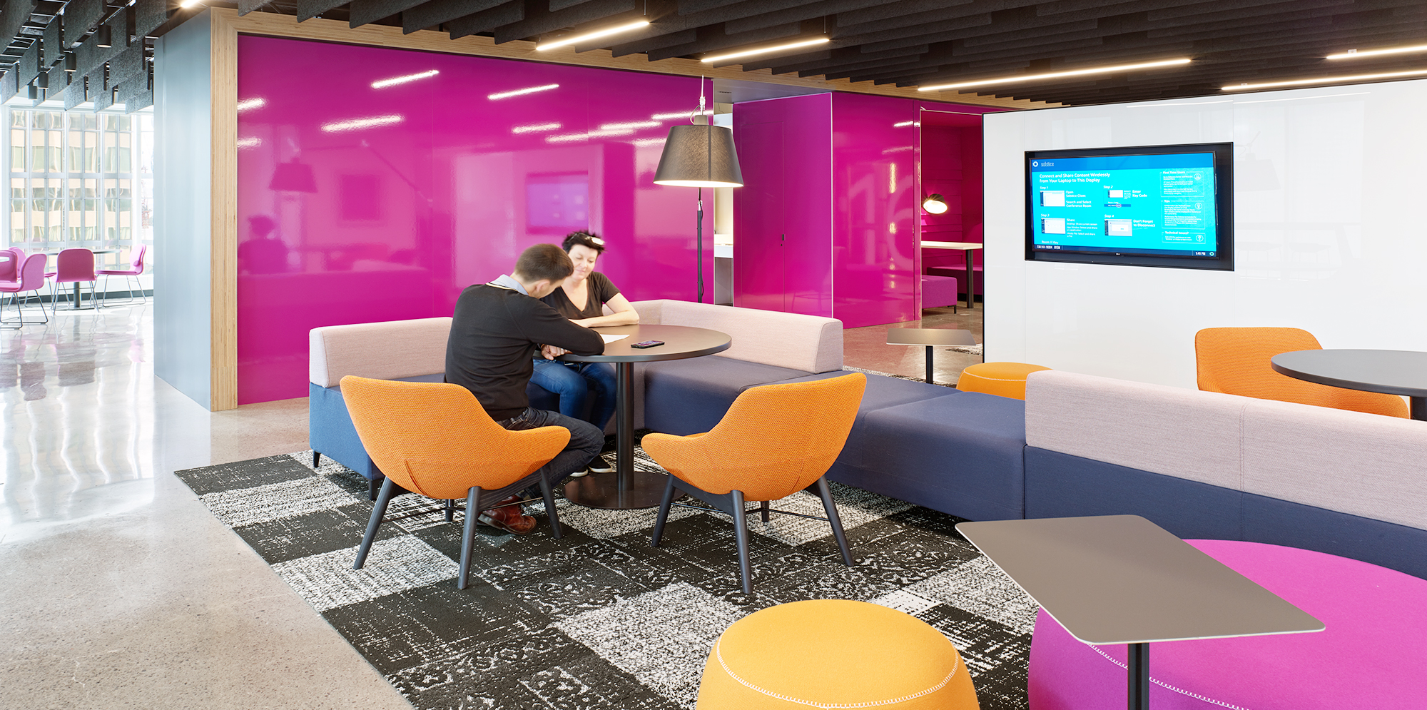 Two people having a conversation colourful seating area inside Capital One Headquarters