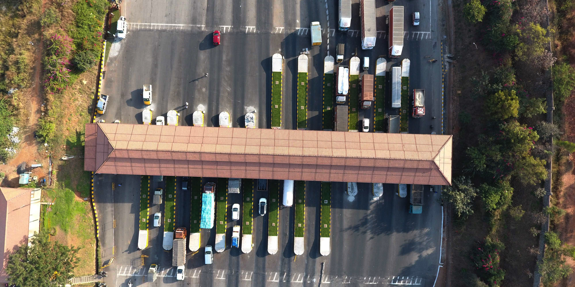 Overhead view of automobiles lined up at a toll booth
