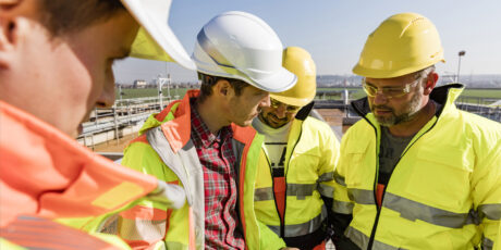 Close up of 4 people talking on a construction site